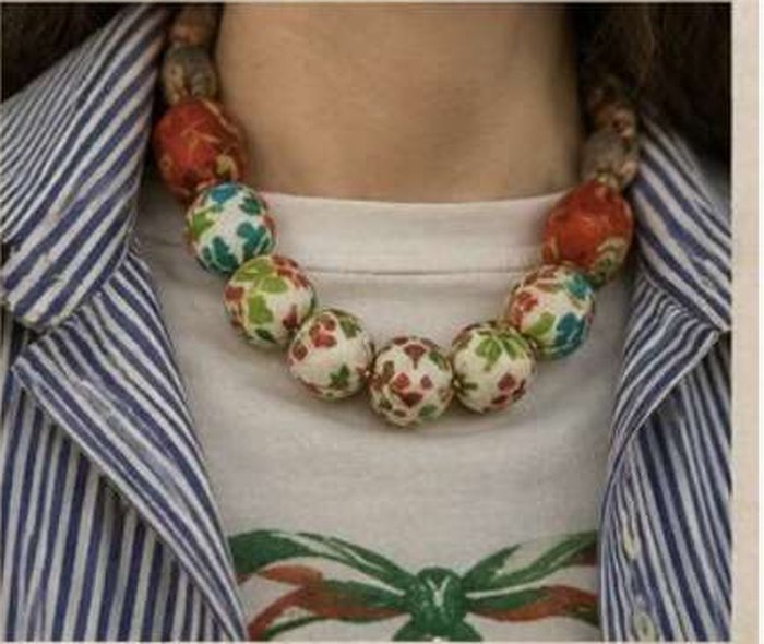 A kantha bead neck piece worn over a striped shirt