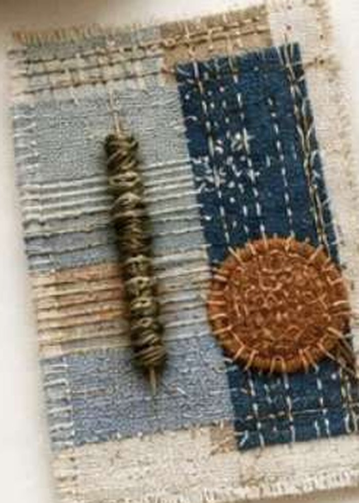 A hand-stitched indigo and denim swatch with a woven cord