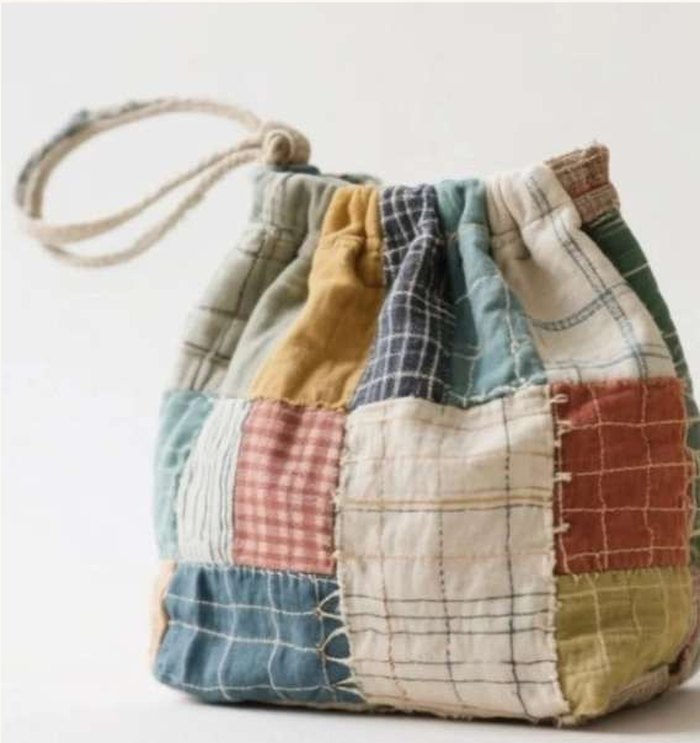 A quilted patchwork potli bag gathered on a cotton drawcord